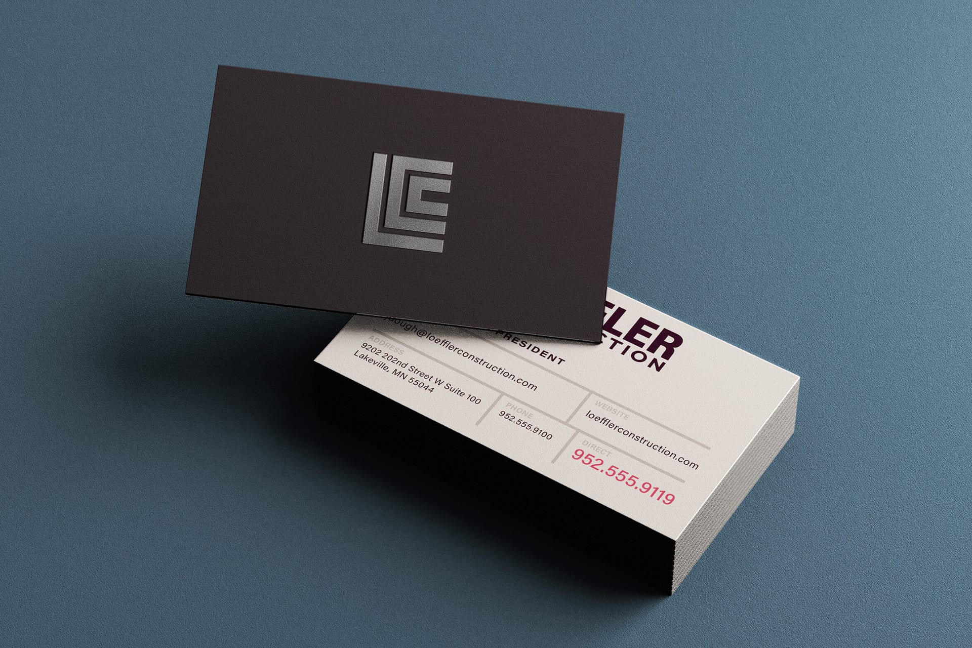 Loeffler business cards: dark card with an embossed cornerstone mark, light card with contact details