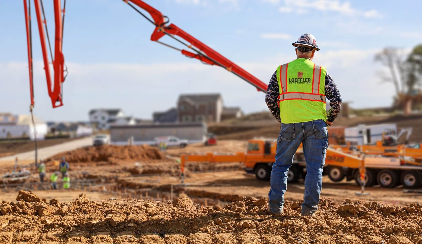 Loeffler Construction logo on a worker's safety vest at a job site